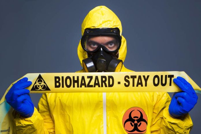 Homem segurando faixa dos elementos químicos mais perigosos